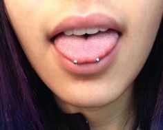 a woman with purple hair and piercing on her tongue