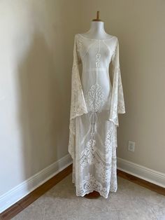 a white dress on a mannequin in a room with tile floor and walls