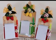 three notepads are decorated with flowers and fruit