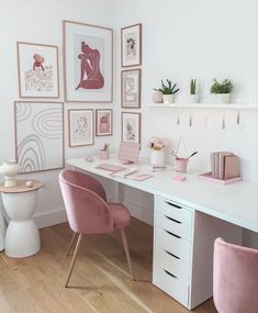 a white desk with pink chairs and pictures on the wall