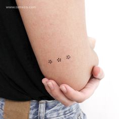 a woman holding her stomach with three small dots on the side of her body that are drawn in black ink