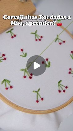 the video is showing how to make a cross stitch christmas ornament with holly berries