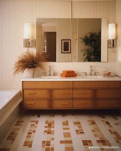 a bathroom with two sinks and a large mirror over it's vanity area, next to a bathtub