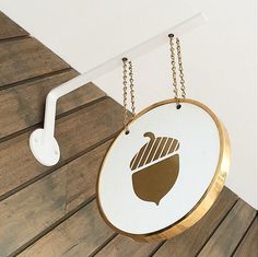 a white and gold circular sign hanging from a hook