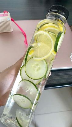 a bottle filled with sliced cucumbers and lemon slices