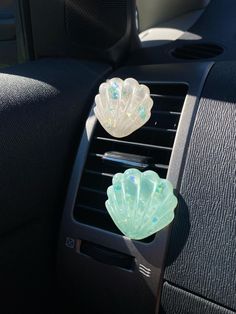 two glass dishes sit on the dash board of a car in front of an air vent