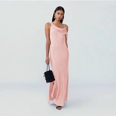 a woman in a pink dress holding a black purse