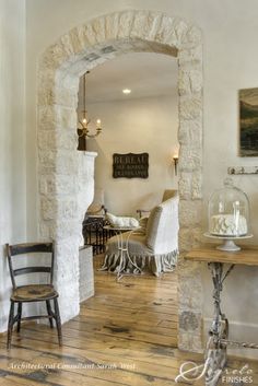 a living room filled with furniture and a stone archway