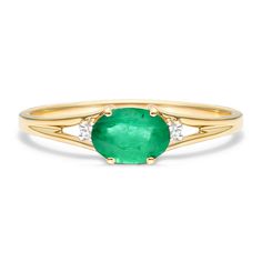 14K Yellow Gold Oval Emerald and Diamond Accent Birthstone Ring. The birthstone of May, Emeralds are said to protect against evil and bring true love, passion and loyalty to those who wear it. This vibrant east-west emerald ring with accent diamond is the perfect piece for your special someone Oval Three Stone Emerald Ring In Yellow Gold, Heirloom Oval Emerald Ring With Three Stones, Emerald Birthstone Ring In Yellow Gold, Yellow Gold Oval Emerald Birthstone Ring, Heirloom Emerald Ring With Gemstone Accents, Heirloom Oval Emerald Ring With Gemstone Accents, Heirloom Oval Emerald Ring Birthstone, Heirloom Oval Emerald Birthstone Ring, Heirloom 14k Gold Emerald Birthstone Ring