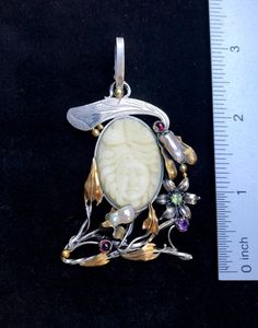 ARTISAN GEMSTONE PENDANTHand-made Sterling Silver. 24k Gold.Stones used: Cameo, Pearls, Peridot, Garnet, Amethyst.Height – 74mm, Width – 40mm.Unique Handcrafted One-of a-kind Design PendantEach Piece of Jewelry in my Collection is Absolutely One of a Kind!When you start wearing a piece of my jewelry you will fall in love with it more and more each day and feel that good Energy and Love that I pass into it while creating this piece of Art.A piece of Art created for you to be inspired and love it Carved Pendant Jewelry For Wedding, White Artisan Jewelry For Ceremonial Occasions, Exquisite Handmade Ceremonial Jewelry, Artisan White Jewelry For Ceremonial Occasions, Ceremonial White Artisan Jewelry, Traditional Ceremonial Intaglio Jewelry, Luxury Carved Pendant Jewelry, Elegant One Of A Kind Jewelry For Ceremonial Use, Exquisite Carved Gold Jewelry