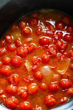 a pot filled with tomatoes and sauce on top of a stove