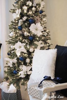 a white christmas tree with blue and silver ornaments