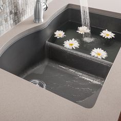 a sink with water running from it and white flowers floating on the counter next to it