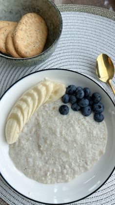 a white plate topped with oatmeal and blueberries next to crackers