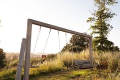 an empty swing set in the middle of a field