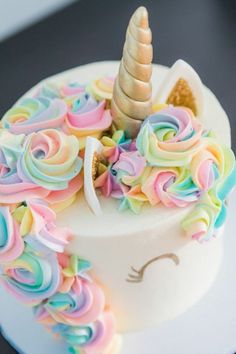 two cakes decorated like unicorns with multicolored icing on them'faces