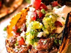 steak with guacamole, tomatoes and sour cream sauce on the side in a tortilla shell