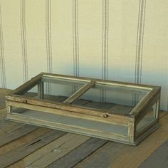 an old wooden box sitting on top of a wooden floor next to a striped wall