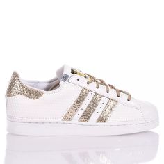 Adidas Superstar White Hive is the super glamorous custom women's sneaker. Entirely in white eco-leather with a geometric texture, featuring the iconic adidas stripes and a textured gold laminated back paired with round gold lurex laces. Adidas Superstar White Hive will also be provided with its original laces. Gold Sneakers With Foil Embossed Logo And Round Toe, Sporty Gold Sneakers With Perforations, White Leather Sneakers With Foil Embossed Logo, Gold Low-top Sneakers With Perforations, Geometric Texture, Zegna Shoes, Marine Serre, Sneaker Wedge, Custom Shoes