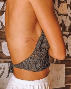 the back of a woman's bra with a tattoo on her left shoulder and right breast