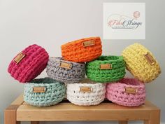 several crocheted baskets sitting on top of a wooden table next to each other