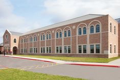 an artist's rendering of a brick building with arched windows and grass in front