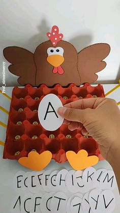 a hand is holding an egg carton with a turkey on it and the letter a