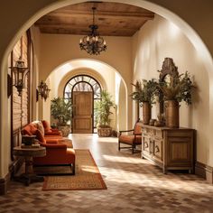 an archway leads into a living room with orange couches and potted plants on either side