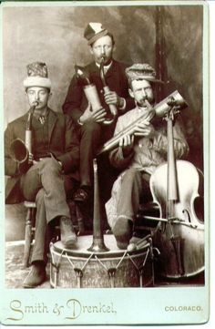 an old black and white photo of three men with musical instruments in front of them