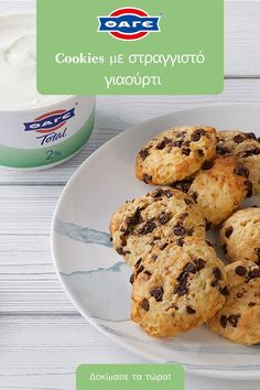 cookies and yogurt on a white plate next to a cup of yogurt