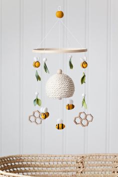 a baby crib mobile with bees and honeycombs hanging from it