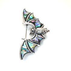 Silver-tone abalone shell bat brooch and Pendant. This great piece can be used as a brooch (pin attached to the back) OR as a pendant (has a section to put your own chain on). Not intended for children ages 13 and under. Also, for many items we can accommodate large orders, so please send us a message. Halloween Brooch Jewelry Gift, Halloween Gift Jewelry Brooch, Gothic Halloween Brooches For Gift, Gothic Halloween Brooch Jewelry, Halloween Gothic Brooch Jewelry, Silver Brooch Jewelry For Halloween, Goth Costume, Abalone Shell, Lapel Pins