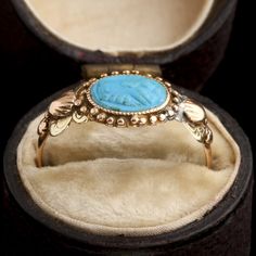 This ring was a commitment jewel. The fede motif (two clasped hands) represents the joining of hands of the couple at a marriage ceremony, a practice that dates back to ancient Rome and was known as 'dextrarum iunctio'. This fede is turquoise-colored glass, pressed in the Georgian era and set into a tricolor gold mounting with shell and flower details at the shoulders. MATERIALS: blue glass, 14k tricolor gold (tests). AGE: c. 1800 SIZE: size 6.5, can be resized; 8.4mm head, 1.3mm shank Georgian Era, Marriage Ceremony, Turquoise Color, Ancient Rome, Tri Color, Blue Glass, Colored Glass, Shells, Turquoise