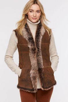 Add warmth and style to any outfit with this uniquely colored Toscana sheepskin vest. The color of an early morning winter sky or a shadow-dappled winterscape, this raw-edge style flatters with a softly draped, collarless open-front design and subtly shaped seams. Two lined slip pockets and an inner zip pocket add wear-everywhere functionality. Pair with a midi skirt and boots for a romantic look, or over city attire for upscale style—either way, you'll be gorgeous and cozy warm. Elegant Brown Winter Vest, Fall Sheepskin Sleeveless Vest, Sleeveless Sheepskin Vest For Fall, Brown Faux Fur Trim Vest For Fall, Brown Vest With Faux Fur Trim For Fall, Midi Skirt And Boots, Sheepskin Vest, Morning Winter, Skirt And Boots