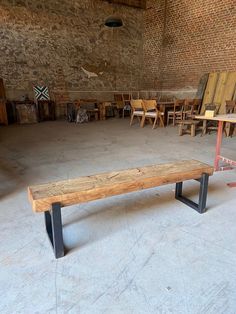 a wooden bench sitting in an empty room next to chairs and tables on the floor