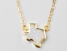 The Texas Opal Necklace combines two of our favorite things, Texas and Opal. The natural stone gives a bit of sparkle to this handmade adjustable 18K gold plated necklace. Makes a statement with other dainty pieces stacked to glow along with the fiery opal necklace. Perfect for your favorite Texan. Pairs well with the Texas Opal Bracelet, or continue the stack with the dainty Opal Necklace. Handmade in Houston, TX USA 18K gold plated Due to the one of a kind nature of the stone, each piece is un Adjustable Gold Opal Jewelry, Dainty Adjustable Opal Necklace, Dainty Opal Adjustable Necklace, Gold Opal Charm Necklace As Gift, Handmade Gold Opal Necklaces, Opal Jewelry With Adjustable Chain For Gift, Handmade Opal Gold Necklace, Handmade Gold Opal Necklace, Minimalist Gold Opal Necklace