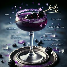 a purple cocktail garnished with blackberries and stars