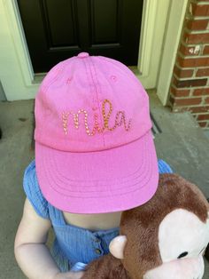 Have your child's name hand embroidered on an adorable ball hat! Single word embroidery. Name or any word.  It fastens with velcro in the back and fits most ages of kids. The model is 2 years old for reference.  Comes in pink, cream and brown. Good for boys and girls! Choose the word you would like embroidered. Choose the thread color you want. Word Embroidery, Disney Hats, Kids Hat, Name Embroidery, Hat Custom, Toddler Hat, Hat Embroidery, Hat Ideas, Embroidered Hats