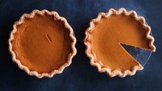 two pies sitting on top of a blue table