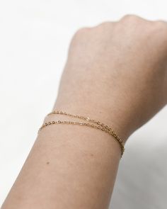 "𝗘𝗮𝘀𝘆 𝗧𝗼 𝗦𝘁𝘆𝗹𝗲, 𝗠𝗮𝗱𝗲 𝗧𝗼 𝗟𝗮𝘀𝘁 Our double wrapped chain is a classic and minimalist addition to your everyday bracelet stack! 𝗠𝗮𝘁𝗲𝗿𝗶𝗮𝗹𝘀 𝗪𝗲 𝗨𝘀𝗲 This bracelet is made entirely with sturdy 14k gold filled or sterling silver pieces. It is safe to wear in the shower, but we recommend avoiding prolonged exposure to chemicals like chlorine to keep your bracelet like new! 𝗟𝗲𝗻𝗴𝘁𝗵 𝗢𝗽𝘁𝗶𝗼𝗻𝘀    This bracelet is available in 5\", 6\", 7\", and 8\" sizes. Each comes with a 1\" extender chain. 𝗠𝗼𝗿𝗲 𝗗𝗲𝘁𝗮𝗶𝗹𝘀 -Chain measures 1.3mm -Spring ring clasp 𝗘𝘅𝘁𝗿𝗮𝘀 𝗮𝗻𝗱 𝗔𝗱𝗱 𝗢𝗻𝘀 Gift Box This gift box has a velour interior and features a sliding drawer style; it is a perfect place to keep your piece when it's not being worn! https://www.etsy.com/li Minimalist Delicate Chain Bracelet For Layering, Dainty 14k Gold Bracelets With Adjustable Chain, Minimalist Delicate Chain Bracelet For Everyday, Dainty Everyday Tarnish Resistant Bracelets, Adjustable Double Chain Bracelet For Everyday, Tarnish Resistant Chain Bracelet For Layering, Dainty Everyday Tarnish-resistant Bracelets, Minimalist Adjustable Chain Bracelets For Layering, Minimalist Everyday Charm Bracelet With Delicate Chain