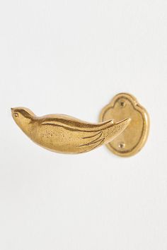 a gold brooch with a bird on it