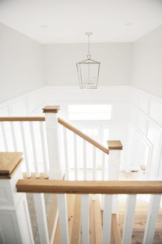 an empty staircase with white railings and wood handrails in a new home