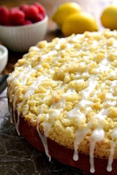 a cake with white icing sitting on top of a table next to some fruit