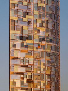 a very tall building with lots of windows on it's side and the sky in the background