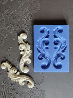 two molds sitting on top of a table next to each other, one is shaped like a flower