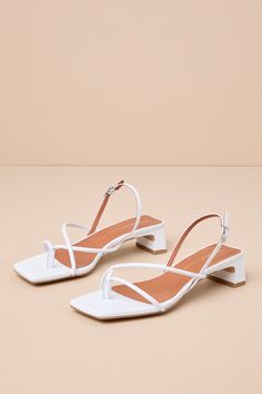 The Intentionally Blank Fifi Ice White Leather Strappy Slingback Low Heel Sandals pair to perfection with warm sunny days! Smooth genuine leather shapes these effortlessly chic sandals that feature a square footbed and a thong-style upper that flows into an asymmetrical strappy vamp. A trendy slingback strap sprouts from the sides and secures at the outstep with a shiny silver buckle. A low, slender block heel completes the coveted look! Available in Euro sizes only. 1. 25" wrapped block heel. C Chic Summer Slingback Sandals With Heel Loop, Elegant High Heel Slingback Sandals For Vacation, Summer Ankle Strap Slingback Sandals With Branded Heel, Chic Slingback Sandals With Strap For Summer, Chic Summer Slingback Pumps With Block Heel, Chic Slingback Sandals For Summer, Chic Summer Slingback Sandals With Strap, Elegant Slingback Sandals For Spring Vacation, Elegant Slingback Sandals For Vacation In Spring