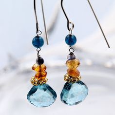 Blue and yellow dangling gemstone earrings with Tanzanite, blue Mystic Quartz, and yellow Citron semi-precious gemstones. These pretty earrings hang about 1.5 inches from the ear. The tear-drop shape Mystic Quartz anchors a series of colorful faceted stones wired to nickel-free silver French ear wire. They are light and comfortable simple and pretty. Topaz Gemstone Dangle Jewelry, Topaz Gemstone Drop Earrings, Blue Gemstone Crystal Drop Earrings, Sapphire Briolette Gemstone Earrings, Blue Topaz Earrings With Gemstone Accents, Blue Gemstone Drop Earrings, Blue Topaz Teardrop Earrings, Sapphire Earrings With Gemstone Accents For Gift, Blue Dangle Birthstone Earrings