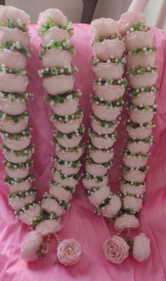 pink roses and green leaves are arranged on the back of a chair with white flowers