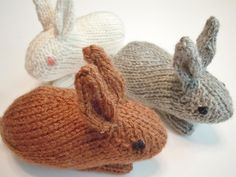 three knitted rabbits sitting next to each other on top of a white countertop