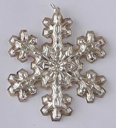 a silver snowflake ornament is shown on a white surface with no background